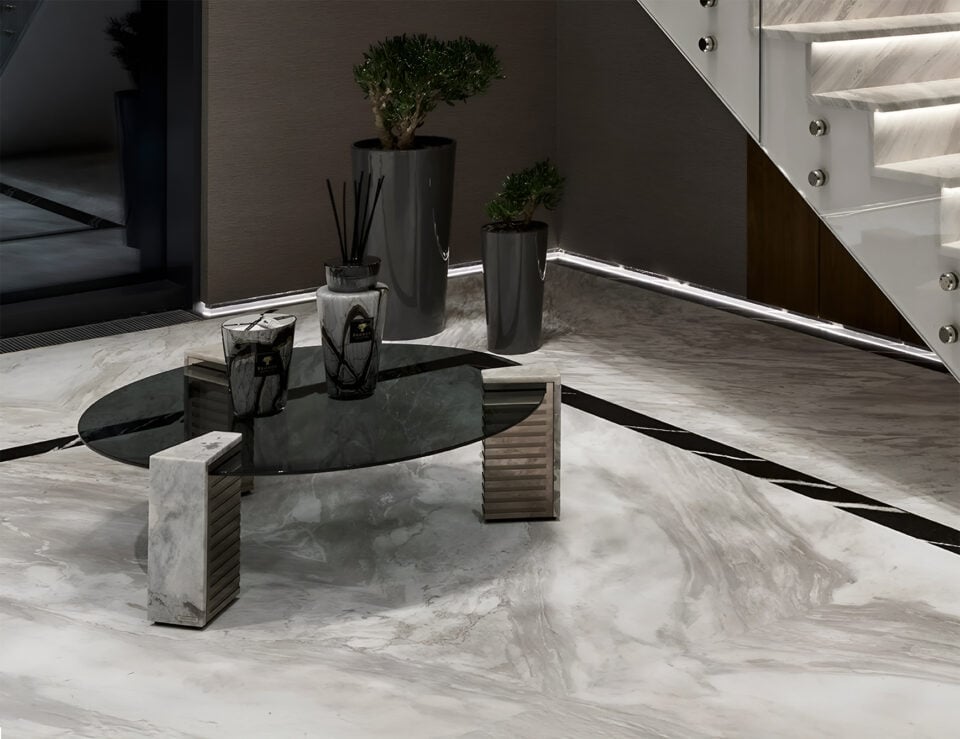 Glass coffee table with marble supports in a living room setting