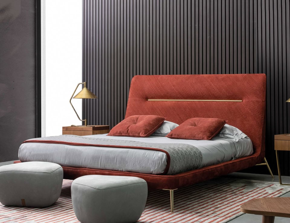 Leather bed with upholstered headboard and metal legs in a bedroom setting