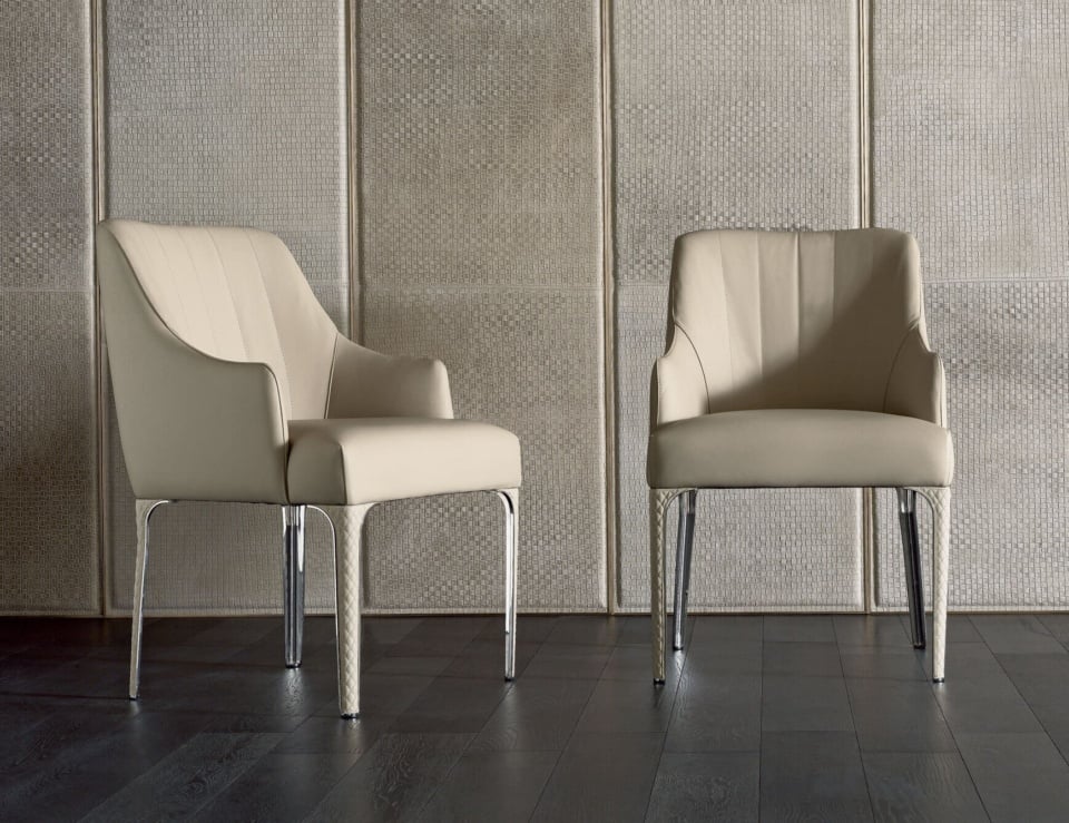 Leather dining chairs with chrome legs placed on dark wood floor.