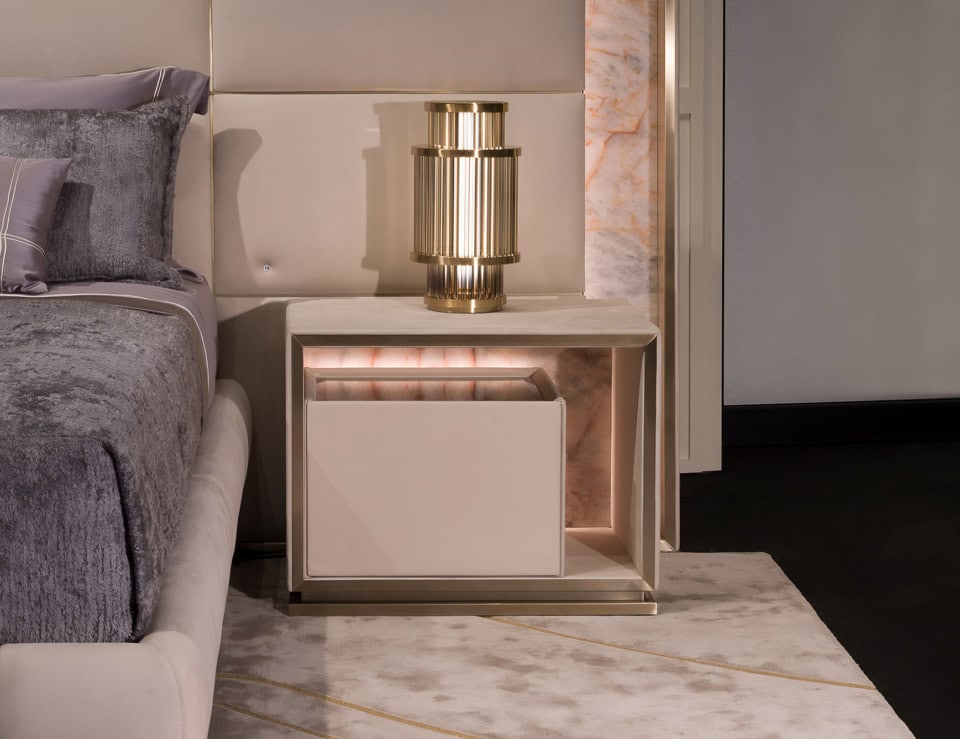 Leather bedside table with open shelf and drawer beside bed