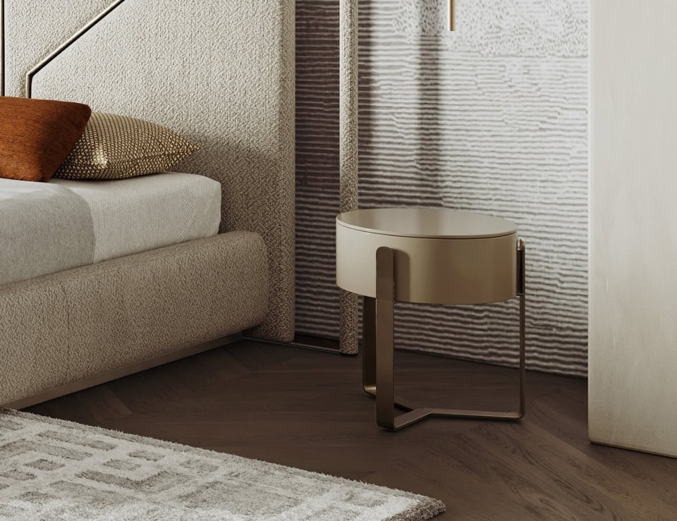 Round wood bedside table with metal base beside bed