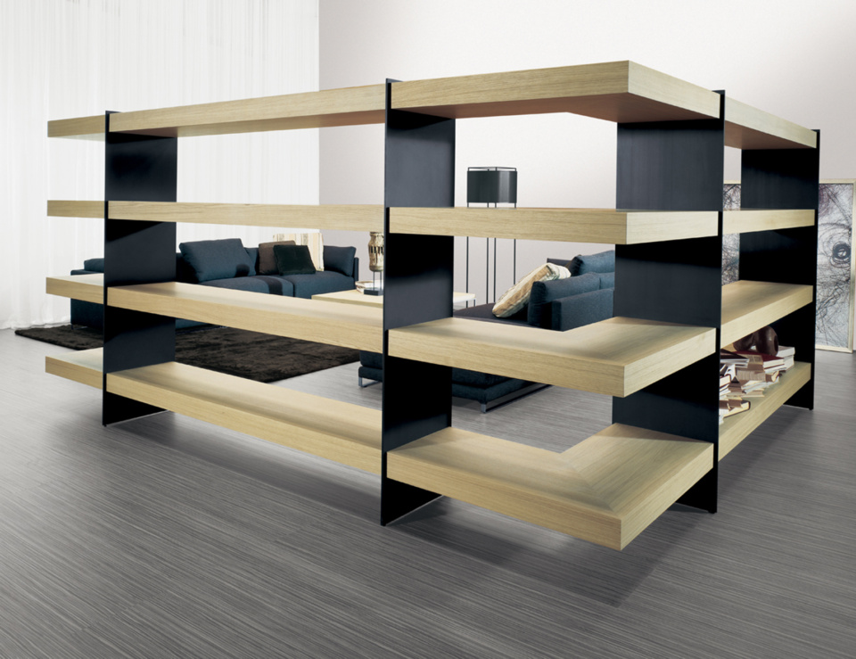 Wood bookcase with oak finish and black panels used as open room divider