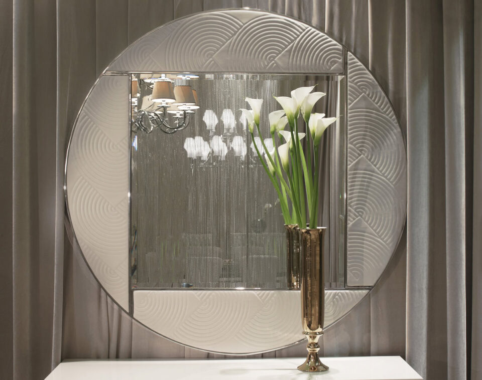 Round metal and mirrored glass wall mirror with patterned frame