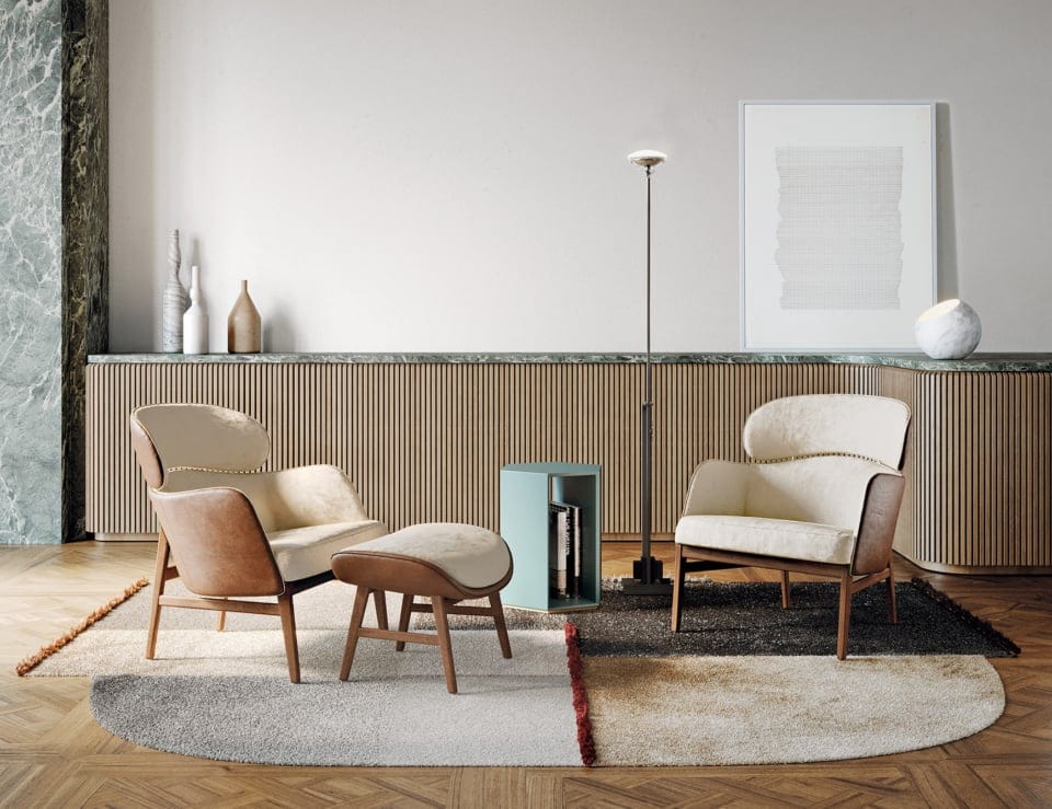 Leather Dafne armchairs with wooden legs and matching ottoman in a living room setting