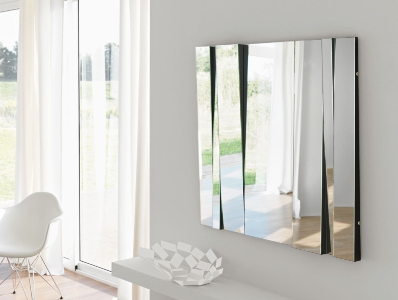 Rectangular wall mirror with angled glass panels in a living room