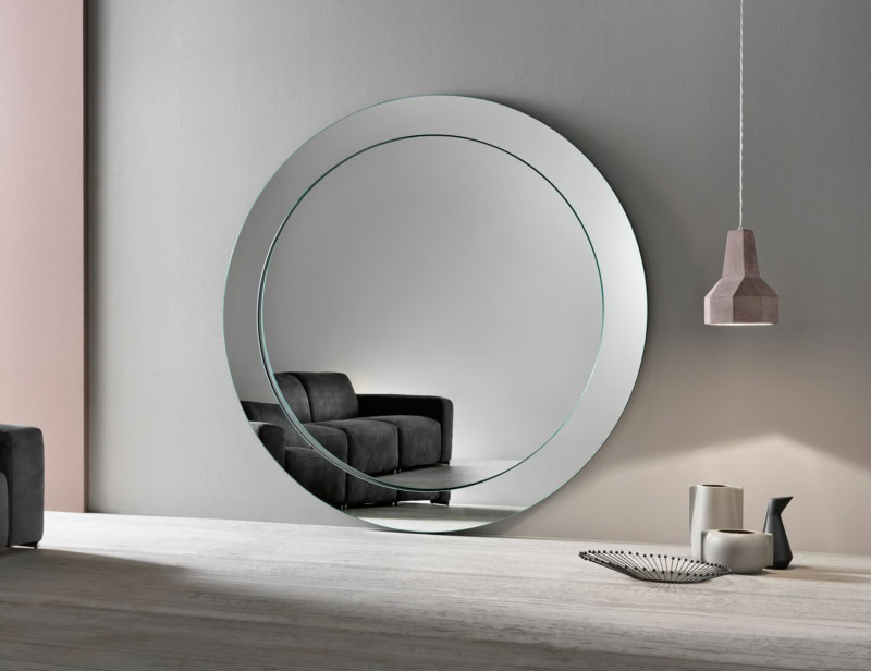 Large round glass wall mirror with beveled edge in living room
