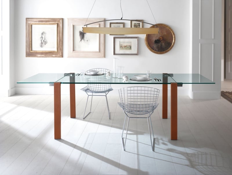 Glass dining table with metal frame and orange legs