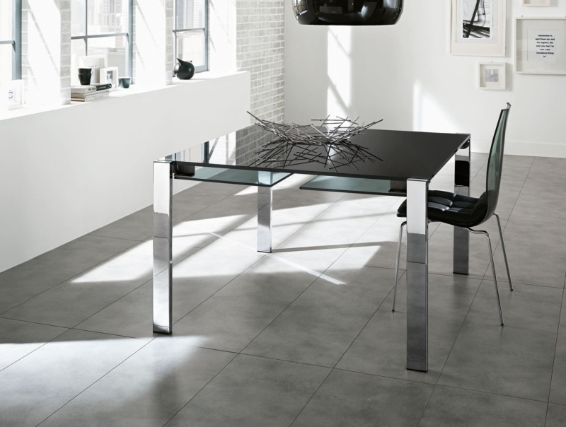 Rectangular glass dining table with chrome metal legs in a tiled room