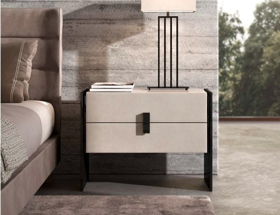 Wood bedside table with two drawers and black frame beside bed