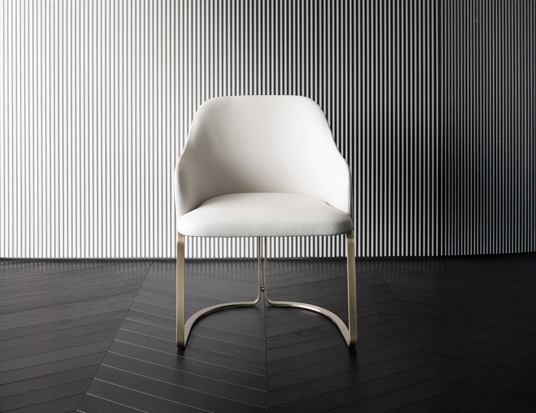 Marie - Leather dining chair with curved metal legs on dark floor