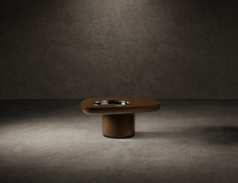 Lacquered wood coffee table with rounded rectangular top on cylindrical base.