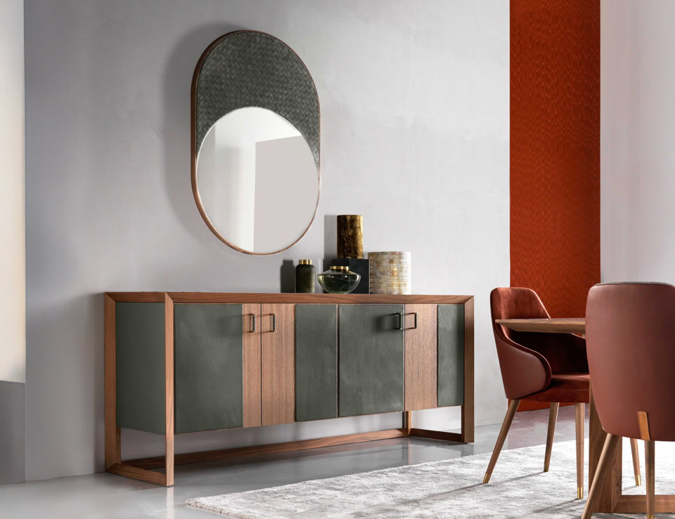 Round leather mirror with wooden frame mounted on wall above sideboard