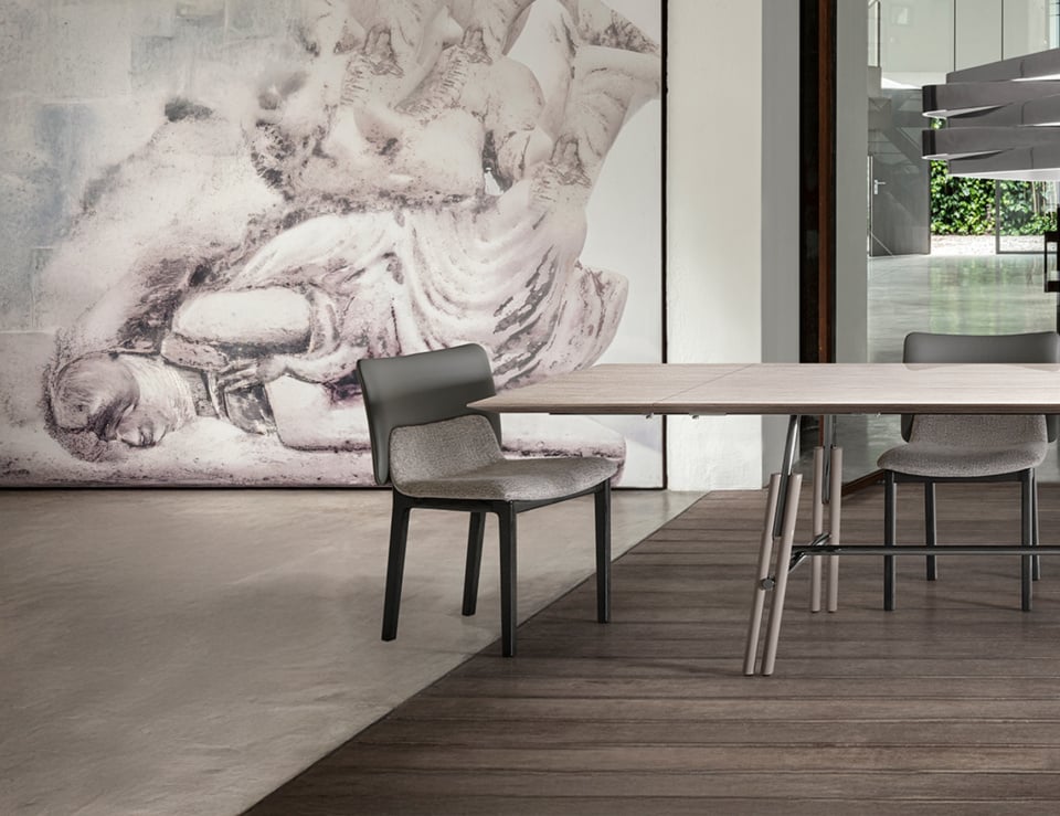 Fabric dining chair with curved back and metal legs beside table