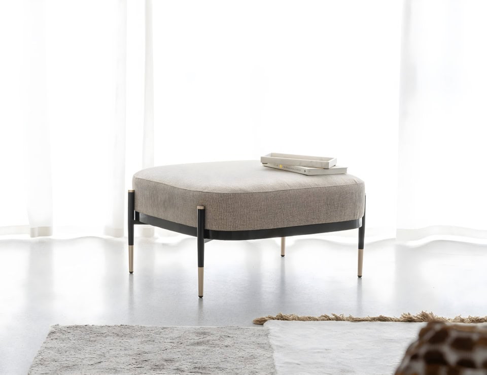 Fabric ottoman with metal legs in a living room setting