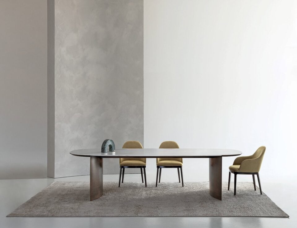 Calacatta marble dining table with oval top and curved pedestal base
