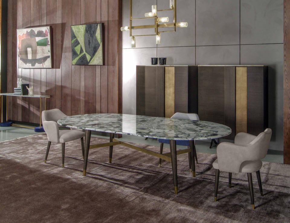 Oval marble dining table with Calacatta Verde finish and wooden legs in dining room setting