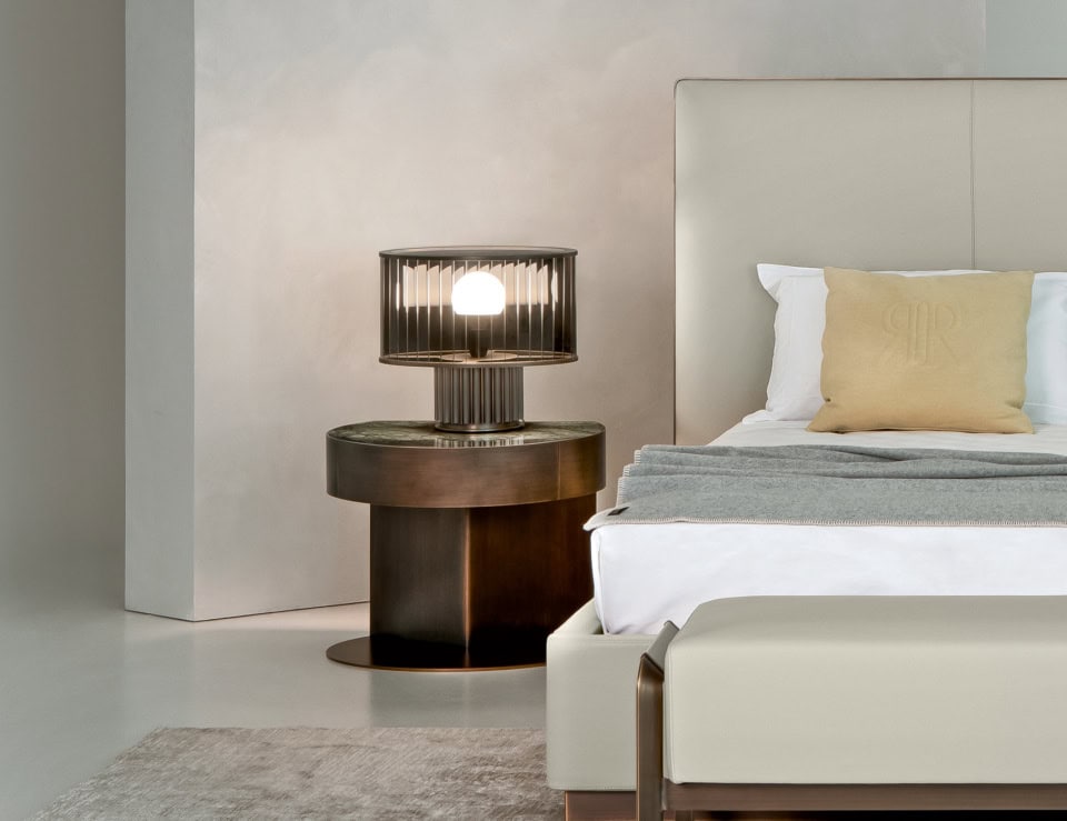 Metal Inca bedside table with bronze finish beside bed