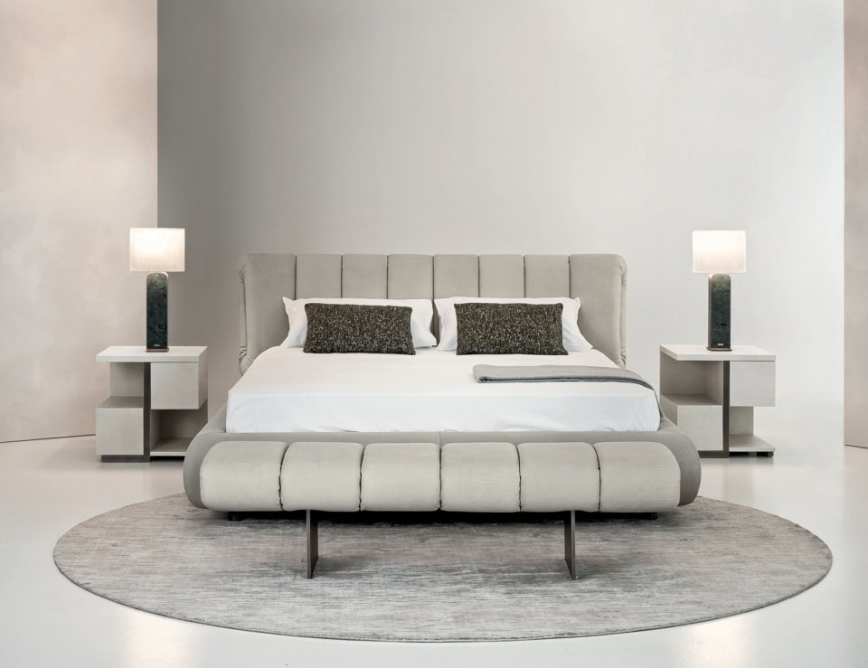 Leather upholstered bed with padded headboard and bench in bedroom setting