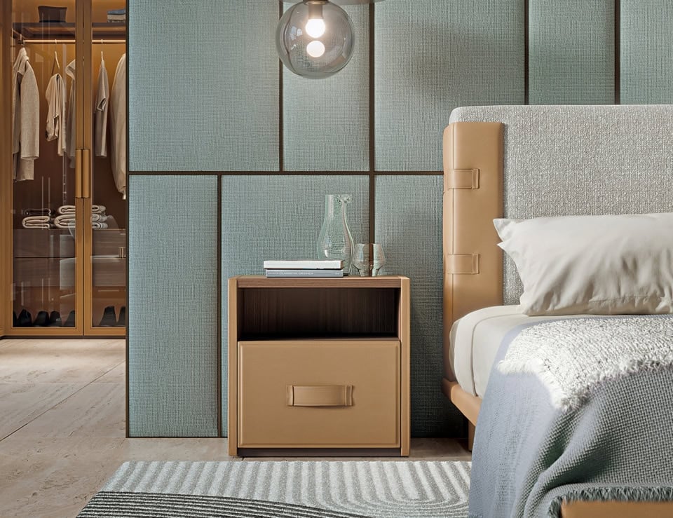 Leather bedside table with single drawer beside bed in bedroom setting