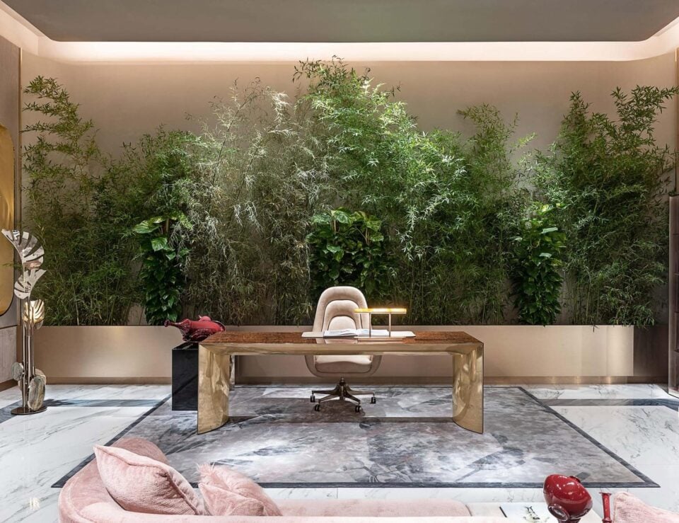 Metal office desk and upholstered chair in workspace with green wall background