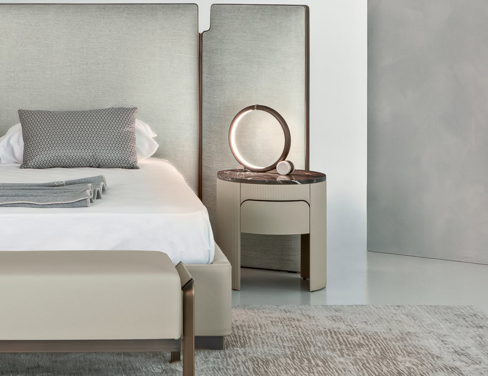 Wood bedside table with Emperador Dark finish beside a bed